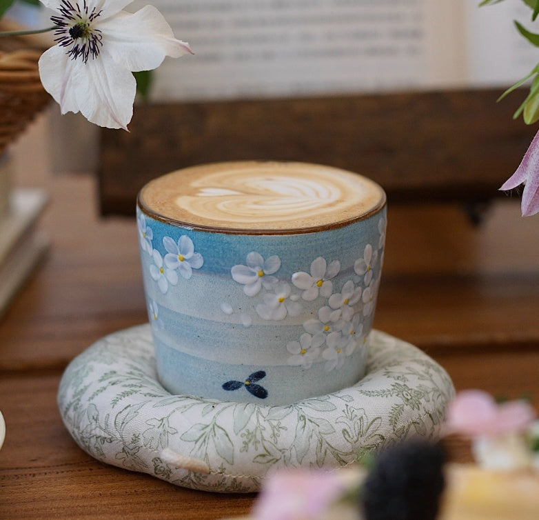 Hand-painted Jingdezhen ceramic coffee cup with white floral underglaze design on a blue background – traditional Chinese style handcrafted cup