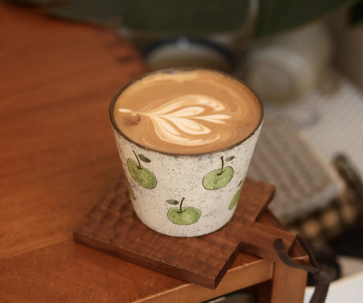 Handcrafted ceramic coffee cup with green apple pattern and purple clay interior – 280ml artisan mug on wooden table