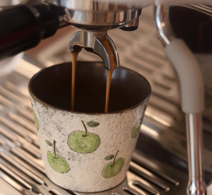 Handcrafted ceramic coffee cup with green apple pattern and purple clay interior – 280ml artisan mug on wooden table