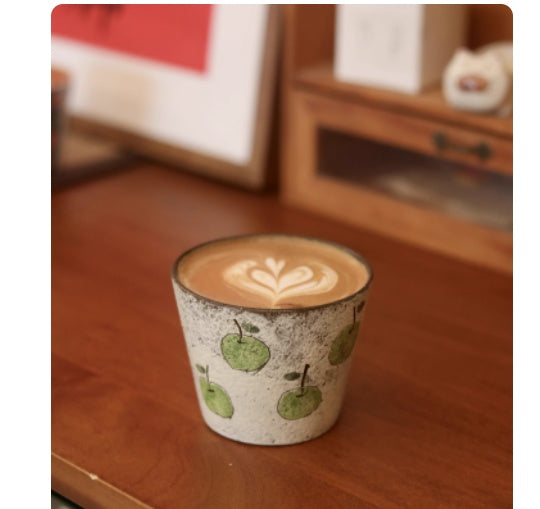 Handcrafted ceramic coffee cup with green apple pattern and purple clay interior – 280ml artisan mug on wooden table