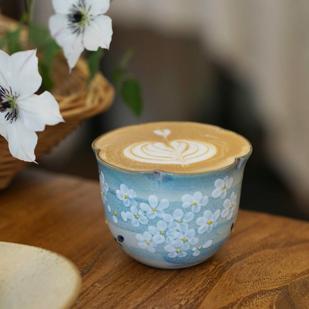Hand-painted Jingdezhen ceramic coffee cup with white floral underglaze design on a blue background – traditional Chinese style handcrafted cup